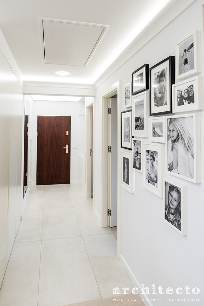 jasny korytarz z galerią rodzinnych zdjęć
